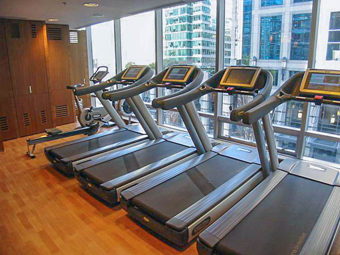 Bright fitness room with large windows, city view, and modern treadmills. - 2806 - 1111 Alberni Street, Vancouver Downtown