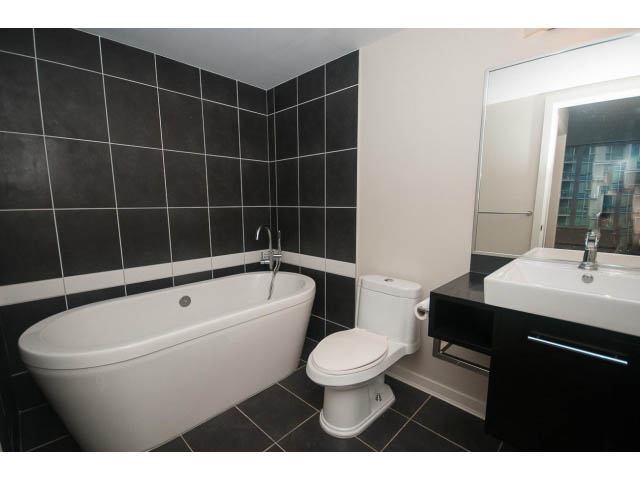 Bright bathroom with black and white tiles, modern sink, and large mirror. - 605 - 633 Abbott St, Vancouver Downtown
