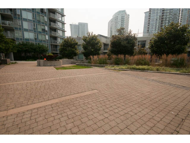 Furnished patio with brick pavers and greenery, city view in the background. - 605 - 633 Abbott St, Vancouver Downtown