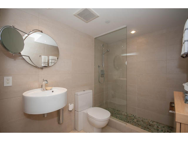 Bright bathroom with modern sink, glass shower, and beige tiles. - 708 - 27 Alexander St, Vancouver Downtown