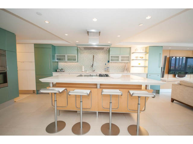 Bright kitchen with light green cabinets, white countertops, and modern bar stools. - 708 - 27 Alexander St, Vancouver Downtown
