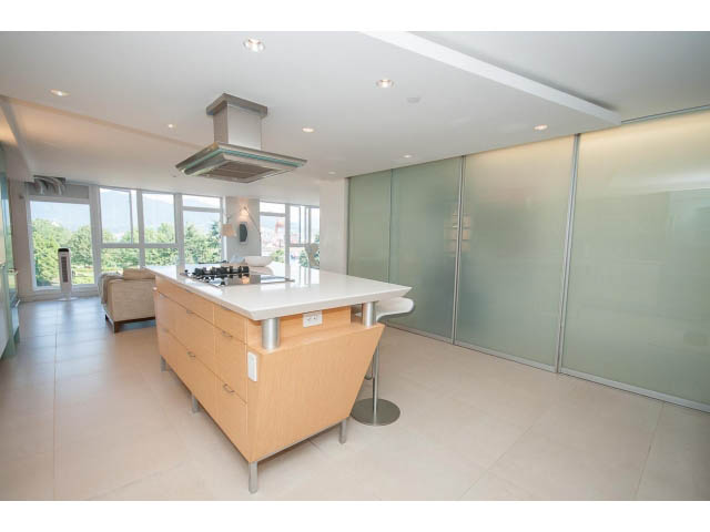 Bright kitchen with wooden cabinets, large windows, and a city view. - 708 - 27 Alexander St, Vancouver Downtown