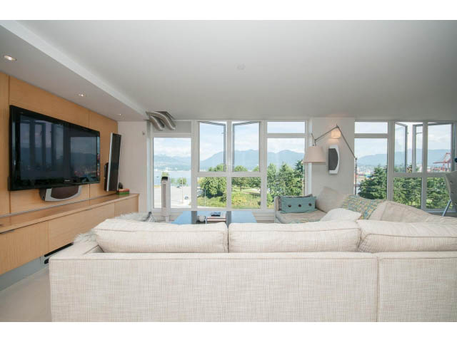 Bright living room with large windows, city view, and modern furnishings. - 708 - 27 Alexander St, Vancouver Downtown