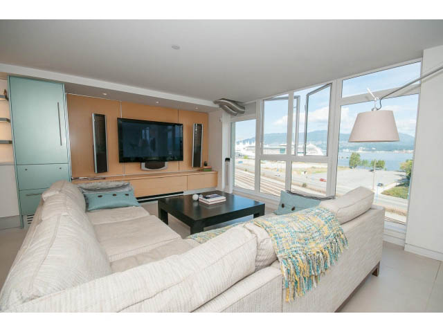 Bright living room with modern furnishings, city view, and large windows. - 708 - 27 Alexander St, Vancouver Downtown