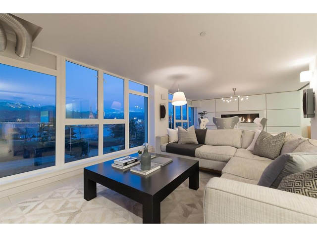 Furnished living room with large windows, city view, and modern decor. - 708 - 27 Alexander St, Vancouver Downtown