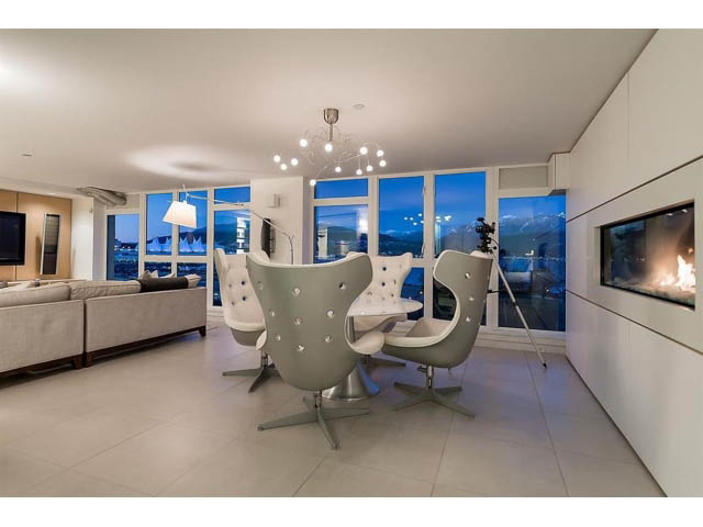 Bright living room with modern furniture, city view, and fireplace. - 708 - 27 Alexander St, Vancouver Downtown