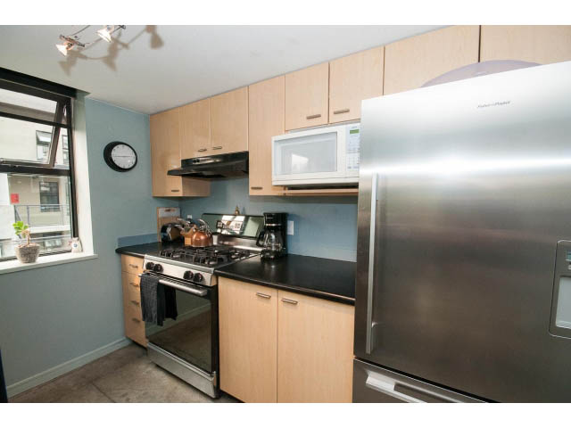 Bright kitchen with stainless steel appliances, light wood cabinets, and a city view. - 716 - 428 West 8th Ave, Vancouver West Side