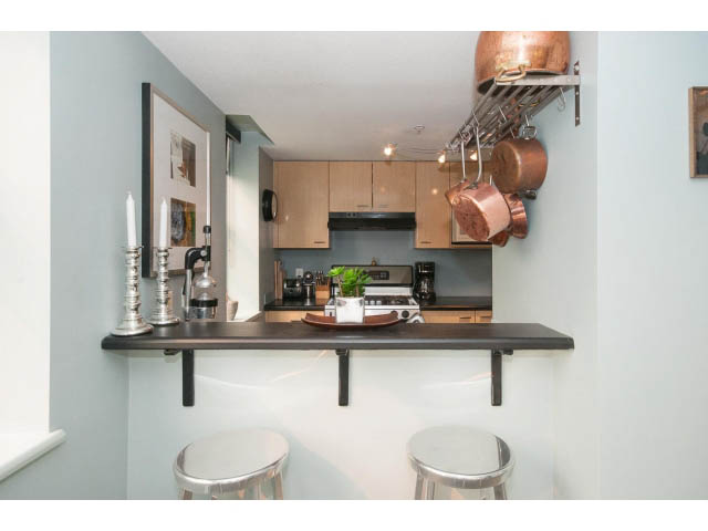 Bright kitchen with modern counter, hanging copper pots, and sleek shelves. - 716 - 428 West 8th Ave, Vancouver West Side