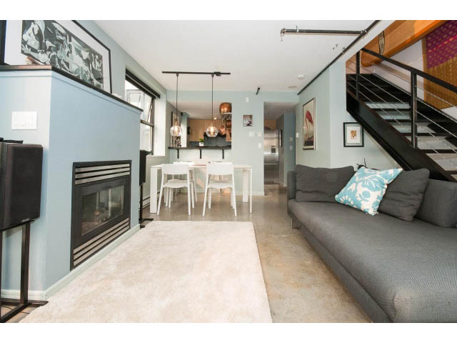 Open-concept living space with modern furnishings and a staircase leading to the loft area. - 716 - 428 West 8th Ave, Vancouver West Side