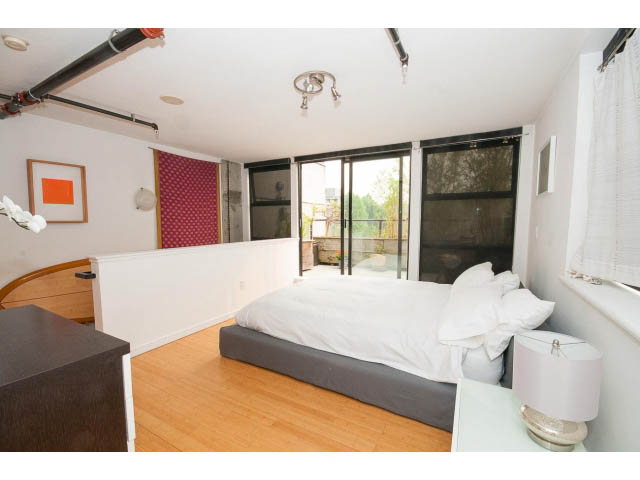 Furnished loft with hardwood floors, large windows, and a cozy bed setup. - 716 - 428 West 8th Ave, Vancouver West Side