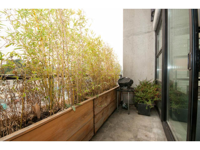 Furnished balcony with bamboo plants and modern glass doors. - 716 - 428 West 8th Ave, Vancouver West Side