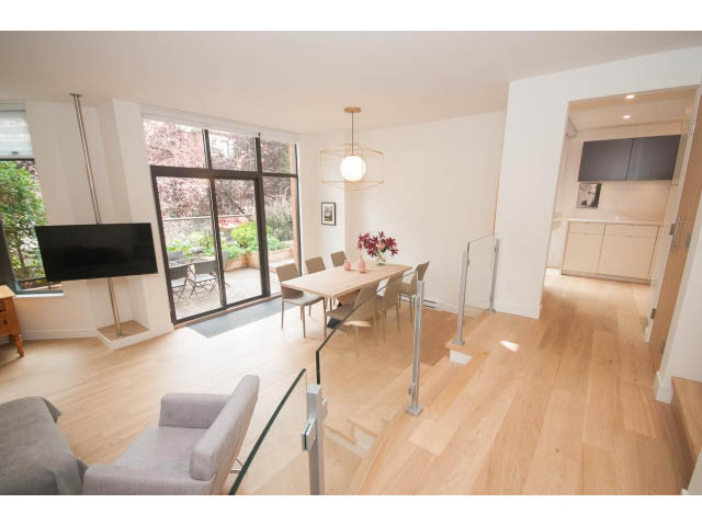 Spacious living room with hardwood floors, modern decor, and a city view. - 103 - 1860 Robson Street, Vancouver Downtown
