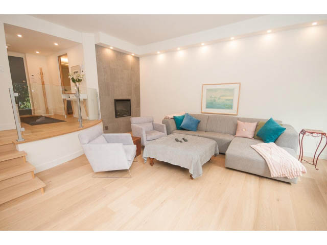 Spacious living room with hardwood floors, modern furniture, and a city view. - 103 - 1860 Robson Street, Vancouver Downtown