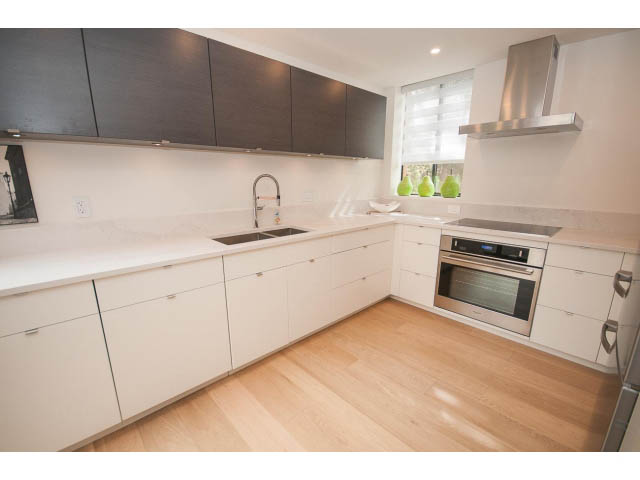 Bright kitchen with white countertops, hardwood floors, and a modern stainless steel range hood. - 103 - 1860 Robson Street, Vancouver Downtown