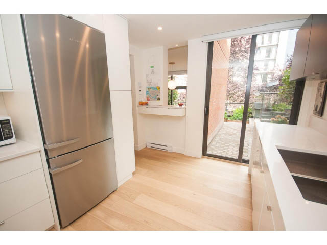 Bright kitchen with white countertops, hardwood floors, and a city view. - 103 - 1860 Robson Street, Vancouver Downtown