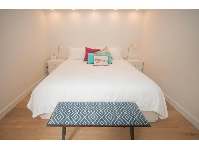 Bright bedroom with hardwood floors and a geometric-patterned table. - 103 - 1860 Robson Street, Vancouver Downtown