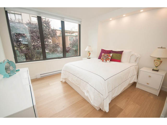 Bright bedroom with hardwood floors, city view, and white furnishings. - 103 - 1860 Robson Street, Vancouver Downtown