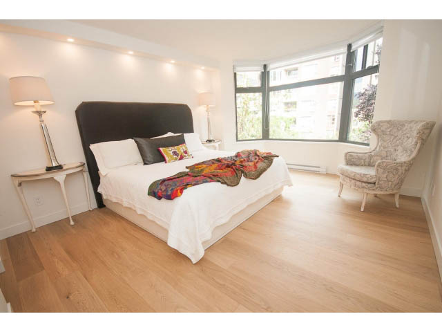 Spacious bedroom with hardwood floors, large window, and cozy seating area. - 103 - 1860 Robson Street, Vancouver Downtown