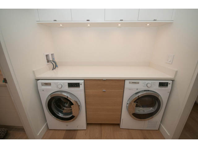 Bright laundry room with white countertops and wooden cabinets, hardwood floors. - 103 - 1860 Robson Street, Vancouver Downtown