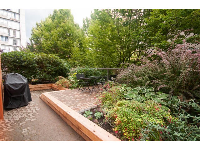 Furnished patio with wooden planters, greenery, and outdoor furniture. - 103 - 1860 Robson Street, Vancouver Downtown