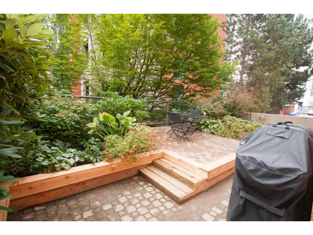Furnished patio with wooden steps, greenery, and outdoor furniture. - 103 - 1860 Robson Street, Vancouver Downtown