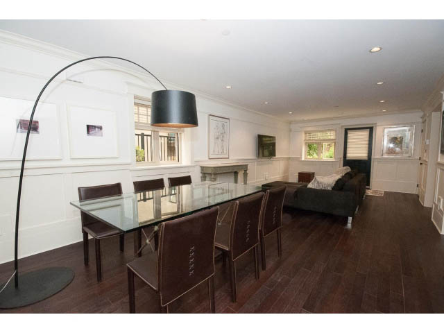 Furnished dining room with dark hardwood floors and a sleek glass table. - 1836 Greer Ave, Vancouver West Side