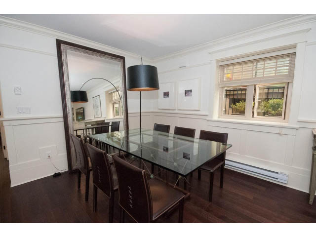 Dining area with glass table, dark wood flooring, and large mirror. - 1836 Greer Ave, Vancouver West Side