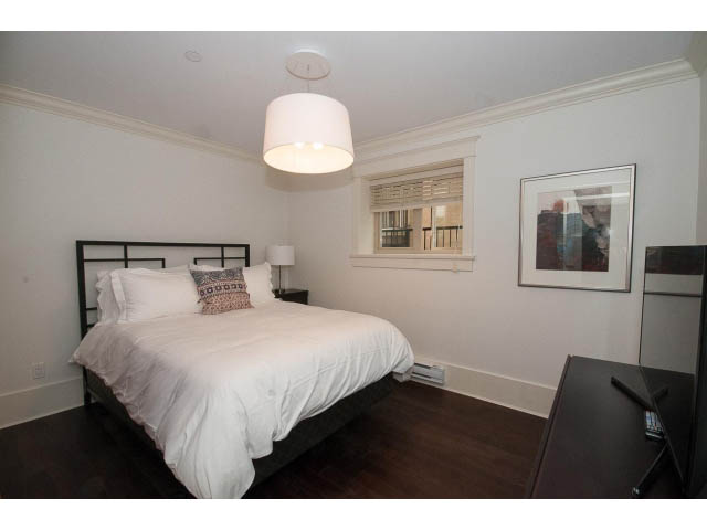 Bright bedroom with hardwood floors and a modern pendant light. - 1836 Greer Ave, Vancouver West Side