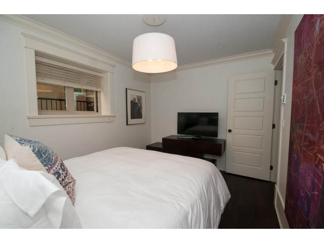 Bright bedroom with twin beds, white walls, and a window with blinds. - 1836 Greer Ave, Vancouver West Side