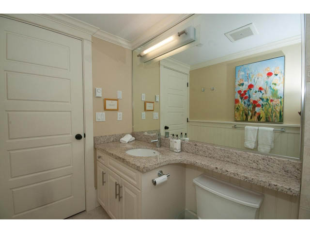 Bright bathroom with granite countertops and floral artwork. - 1836 Greer Ave, Vancouver West Side