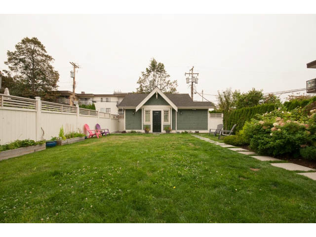 Bright living room with greenery and patio furniture. - 1836 Greer Ave, Vancouver West Side