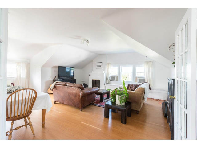 Bright living room with hardwood floors and a cozy corner setup. - Upper - 732 East 9th St, North Vancouver