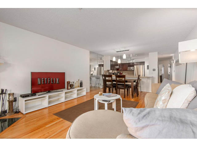 Bright living room with hardwood floors, modern furniture, and a Netflix TV. - 101 - 2288 Laurel st., Vancouver West Side