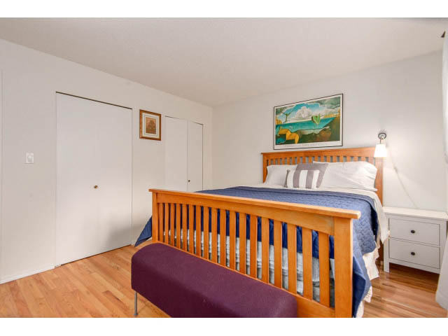 Furnished bedroom with wooden bunk beds, hardwood floors, and a painting on the wall. - 101 - 2288 Laurel st., Vancouver West Side