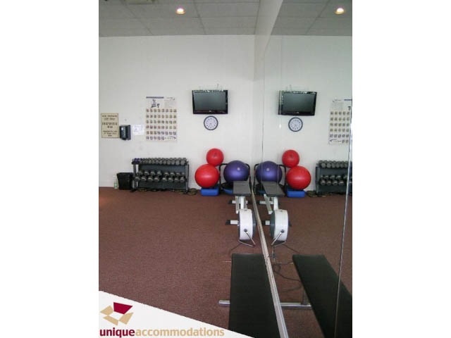 Furnished living room with exercise equipment and mirrors. - 1204 - 1625 Hornby St, Vancouver Downtown