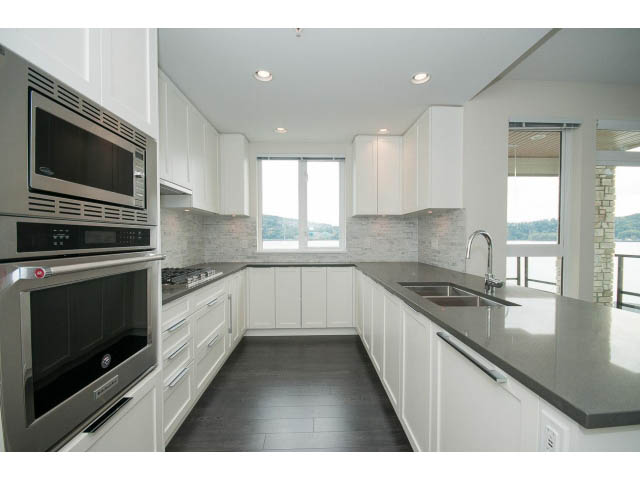 Bright kitchen with modern stainless steel appliances, granite countertops, and a city view. - 303 - 3825 Cate's Landing, North Vancouver