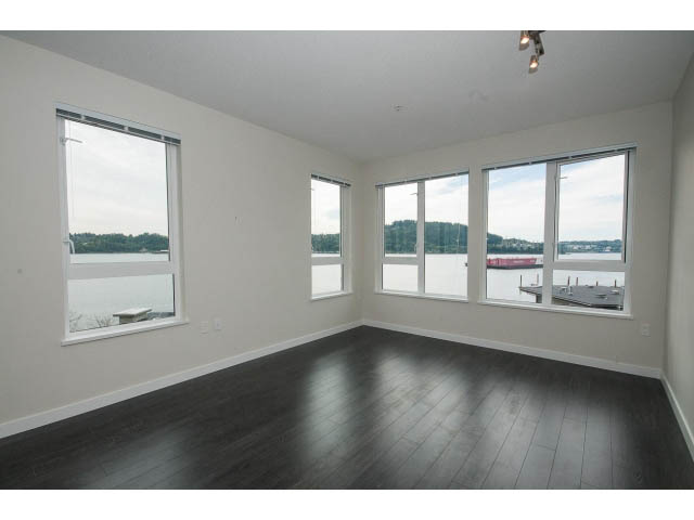 Bright living room with hardwood floors and city view. - 303 - 3825 Cate's Landing, North Vancouver