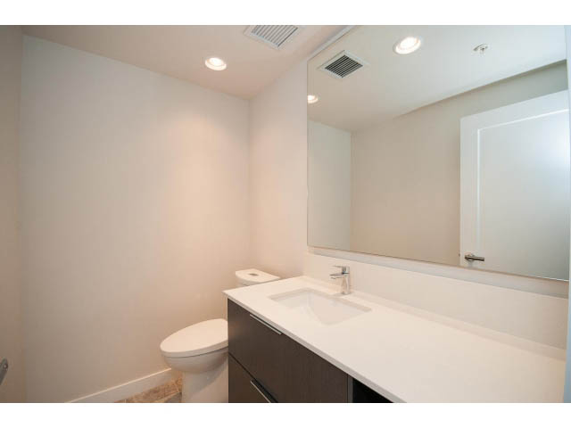 Bright bathroom with modern vanity and large mirror. - 303 - 3825 Cate's Landing, North Vancouver