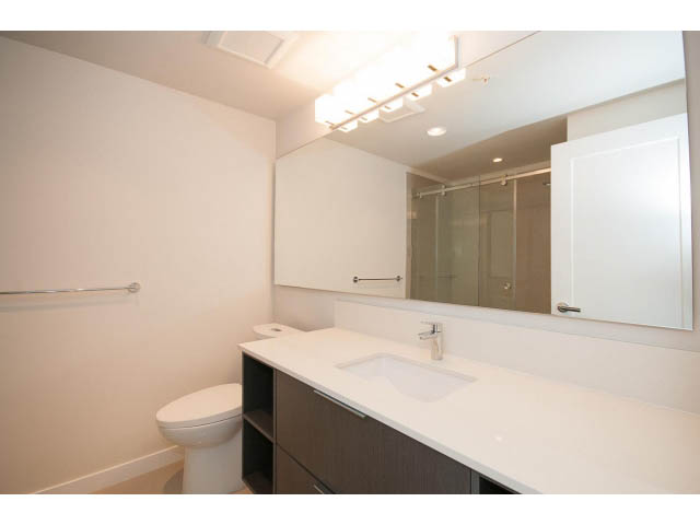 Bright bathroom with modern vanity and large mirror. - 303 - 3825 Cate's Landing, North Vancouver