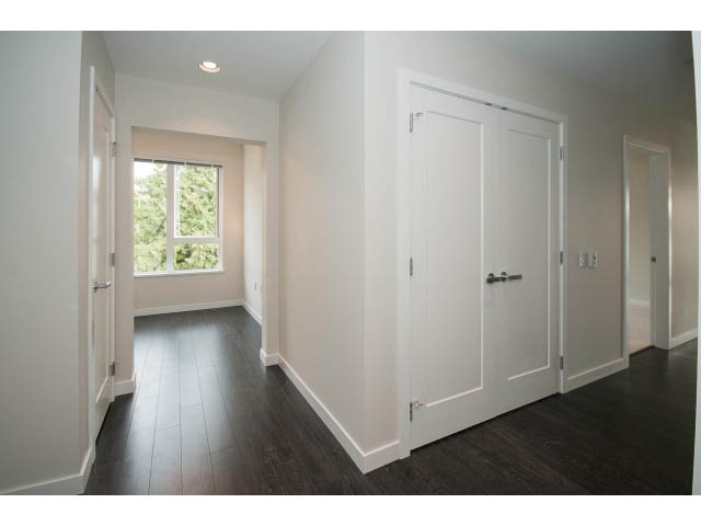 Bright and airy living room with hardwood floors and a large window. - 303 - 3825 Cate's Landing, North Vancouver