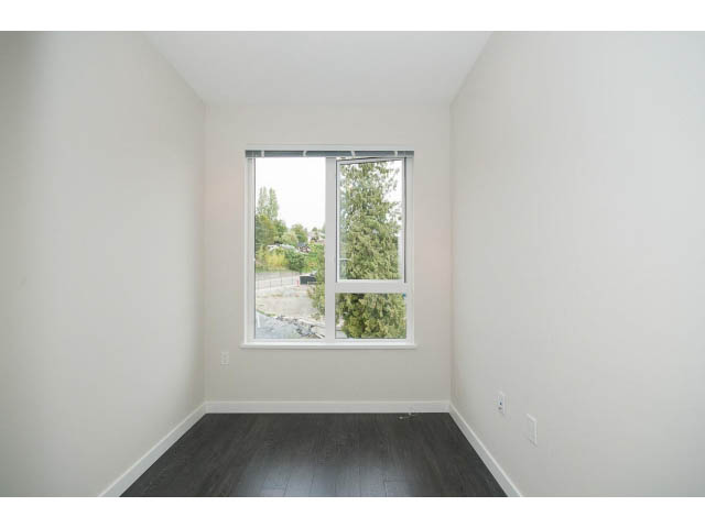 Bright den with hardwood floors and large windows offering a view of trees and a distant cityscape. - 303 - 3825 Cate's Landing, North Vancouver