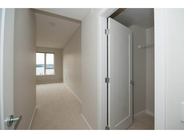 Den with carpeted floor, sliding closet doors, and a view of the water. - 303 - 3825 Cate's Landing, North Vancouver