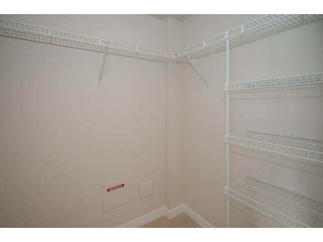 Spacious walk-in closet with white wire shelving and ample storage space. - 303 - 3825 Cate's Landing, North Vancouver