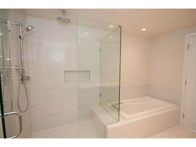 Spacious bathroom with marble tiles and glass shower enclosure. - 303 - 3825 Cate's Landing, North Vancouver