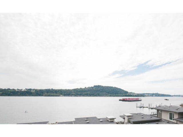 Bright living room with a stunning city view and waterfront access. - 303 - 3825 Cate's Landing, North Vancouver