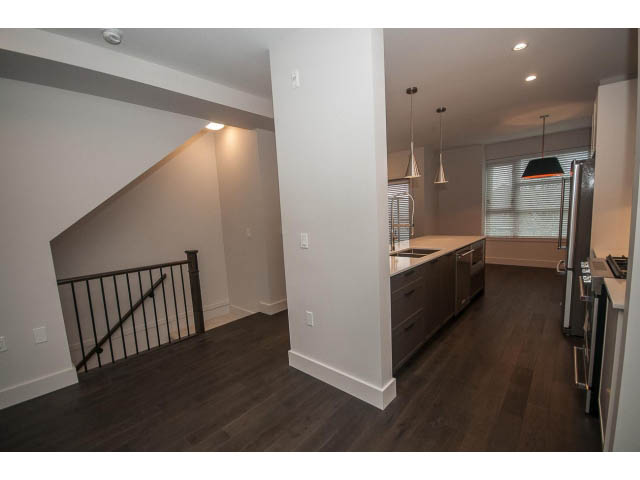 Bright kitchen with dark hardwood floors and modern pendant lights. - 5 - 244 5th E St, North Vancouver