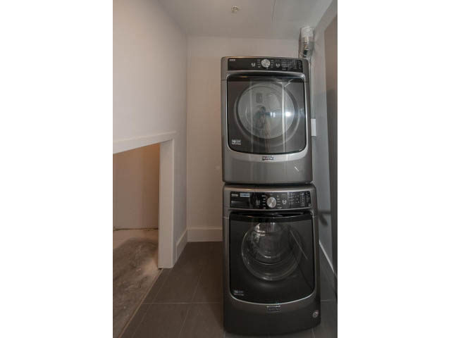 Laundry room with stacked washer and dryer, granite countertop. - 5 - 244 5th E St, North Vancouver