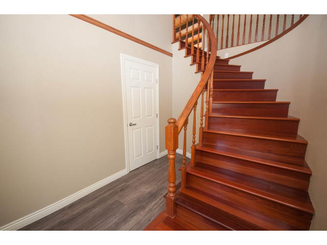 Furnished entryway with wooden staircase and hardwood floors. - 4135 Golf drive, North Vancouver