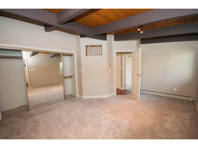 Spacious living room with exposed beams and carpeted floors. - 4135 Golf drive, North Vancouver