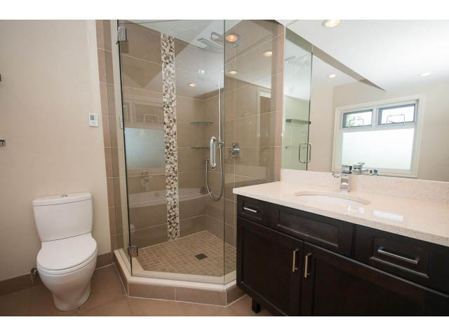 Spacious bathroom with dark cabinets, granite countertops, and a walk-in shower. - 4135 Golf drive, North Vancouver